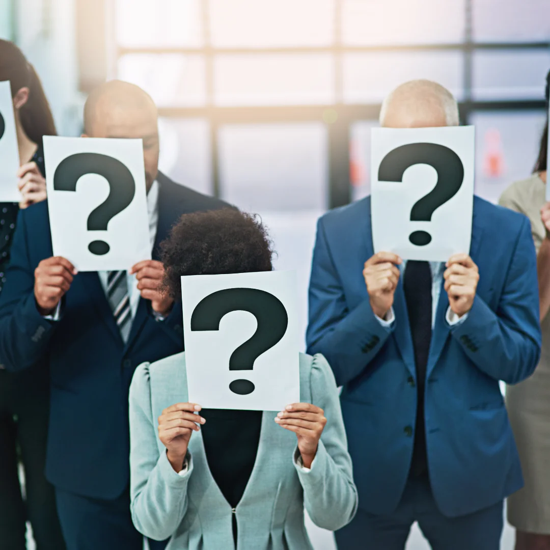 Group of business people holding papers with question marks, symbolizing got questions or uncertainty